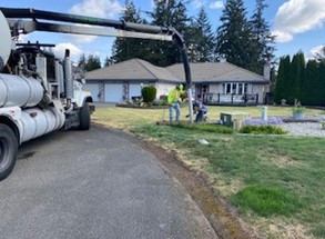 Two Washington Water employees surveying a service line cover in a residential area